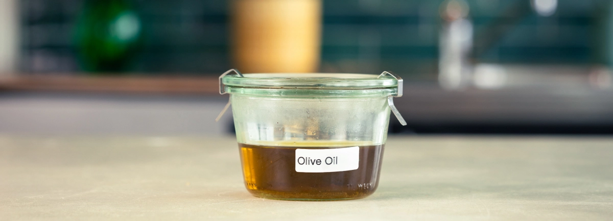 Conservació de l’oli d’oliva infusionat amb cànnabis Recipient de vidre amb oli d’oliva infusionat amb cànnabis, etiquetat i a punt per guardar.