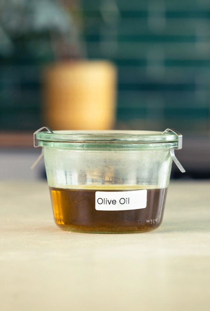 Conservació de l’oli d’oliva infusionat amb cànnabis Recipient de vidre amb oli d’oliva infusionat amb cànnabis, etiquetat i a punt per guardar.