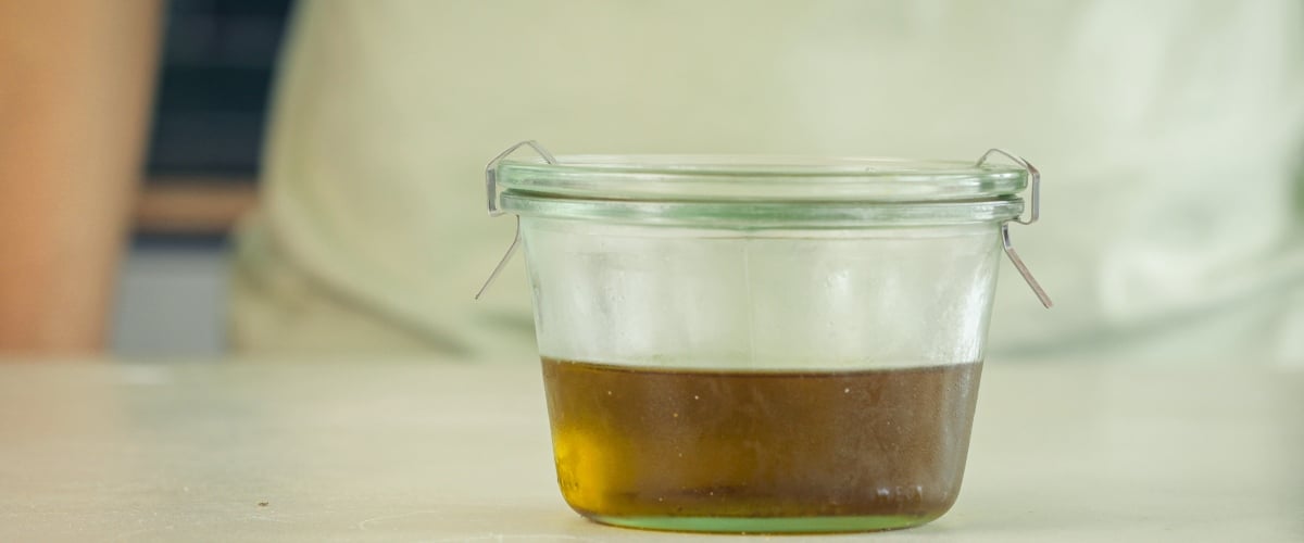 Step 4: Store the Cannabis-Infused MCT Oil Properly Pouring cannabis-infused MCT oil into an airtight amber glass bottle for storage, final step of the infusion process