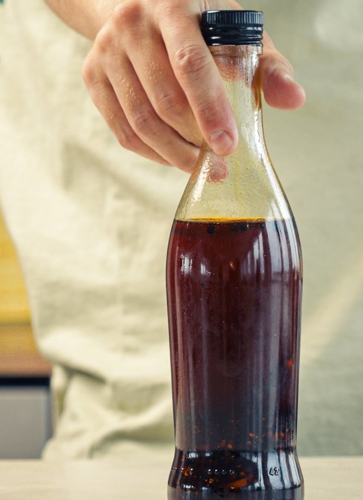 Step 4: Store the Cannabis-Infused Chilli Oil Properly Sealed glass bottle filled with cannabis-infused chilli oil stored for preservation in a kitchen setting